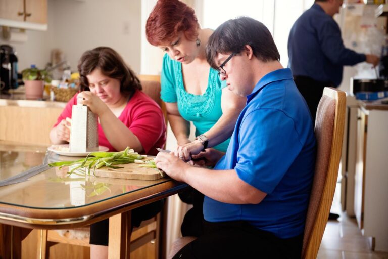 Adults preparing a meal together with support in a home kitchen.