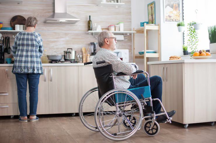 A wheelchair user in a bright, accessible home kitchen.